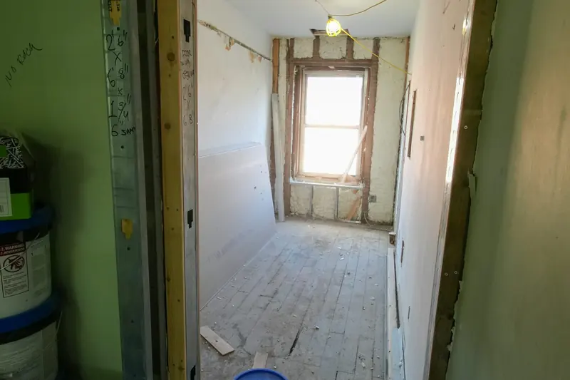 Una estancia en obras con suelo, paredes y puerta sin terminar.